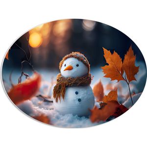 PVC Schuimplaat Ovaal - Sneeuwpop met Bruine Sjaal en Muts in de Sneeuw tussen de Herfstbladeren - 68x51 cm Foto op Ovaal (Met Ophangsysteem)