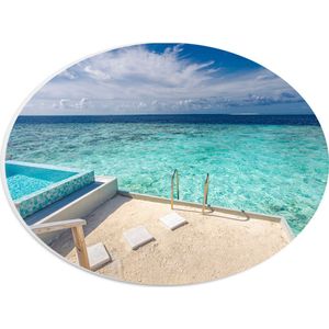PVC Schuimplaat Ovaal - Zwembad boven Tropisch Blauwe Zee in Luxe Vakantieverblijf - 28x21 cm Foto op Ovaal (Met Ophangsysteem)