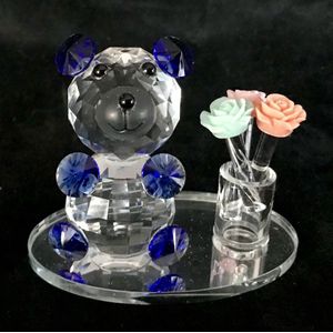Kristal glas beertje blauwe kleur met kleine vaas en drie verschillende kleuren rozen  8x7x5cm staat op een ovale spiegel