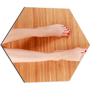 Dibond Hexagon - Bovenaanzicht van Vrouwen Benen met Roodkleurige Teennagels op Houten Ondergrond - 50x43.5 cm Foto op Hexagon (Met Ophangsysteem)