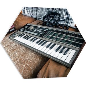 PVC Schuimplaat Hexagon - Oud Keyboard op Bruine Leren Bank - 60x52.2 cm Foto op Hexagon (Met Ophangsysteem)