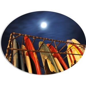 PVC Schuimplaat Ovaal - Rij Surfplanken in Hek op het Strand tijdens de nacht - 68x51 cm Foto op Ovaal (Met Ophangsysteem)