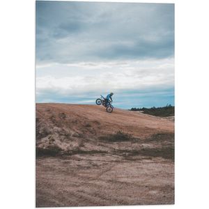 WallClassics - Vlag - Blauwe Motorrijder op één Wiel bij Heuvel - 40x60 cm Foto op Polyester Vlag