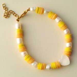 Armband met parels, gele en oranje katzuki kralen, parelmoeren hart en een goudkleurige sluiting