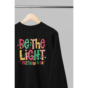 Foute kersttrui - Be the light - Wurban Wear | 18+ | Grappige sweater | Leuk cadeau | Unisex sweater | Oversized sweater | Kersttrui heren | Foute kerstkleding | Kerst sweater | Kerst diner | Kersttrui dames | Foute kersttruiendag 2025 | Zwart