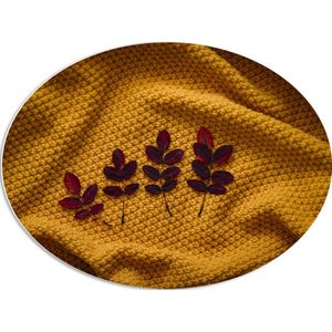 PVC Schuimplaat Ovaal - Kleine Rode Blaadjes van Plant op Okergeel Deken - 80x60 cm Foto op Ovaal (Met Ophangsysteem)