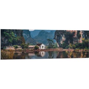 WallClassics - PVC Schuimplaat - Huisje bij Water en Bergen - Vietnam - 150x50 cm Foto op PVC Schuimplaat (Met Ophangsysteem)