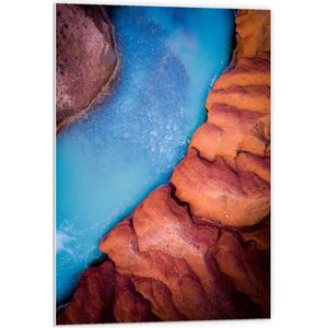 WallClassics - PVC Schuimplaat- Helder Blauw Stromend Water tussen Stenen - 60x90 cm Foto op PVC Schuimplaat