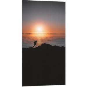 WallClassics - Vlag - Man lopend over Berg aan de Zee met Zonsondergang - 50x100 cm Foto op Polyester Vlag