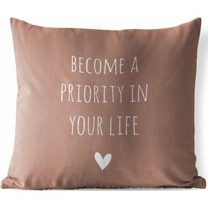 Tuinkussen - Engelse quote ""Become a priority in your life"" met een hartje tegen een bruine achtergrond - 40x40 cm - Weerbestendig