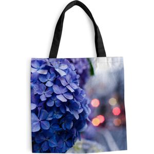 MuchoWow® Schoudertas - Strandtas - Big Shopper - Boodschappentas - Close-up van een blauwe hortensia en een stad op de achtergrond - 40x40 cm - Katoenen tas